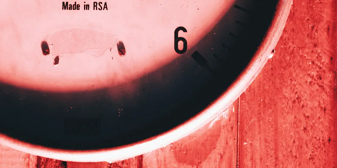 A close up of a clock on a wooden surface